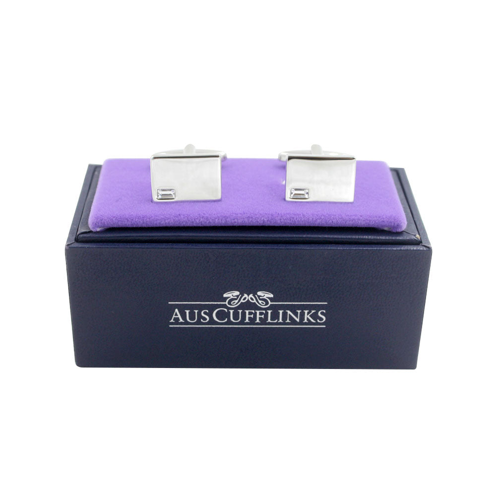 The Diamante Silver Stone Cufflinks are elegantly displayed on a purple velvet cushion, resting atop a black box labeled "AUSCUFFLINKS.