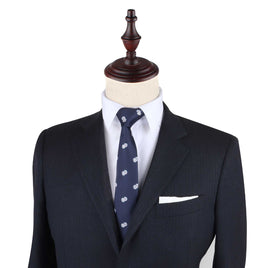A mannequin displaying a dark suit with a white shirt and the Dice Print Tie featuring a light blue pattern exudes an effortless style.