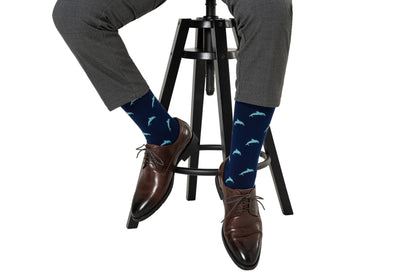 A man sitting on a stool wearing a pair of Dolphin Socks.