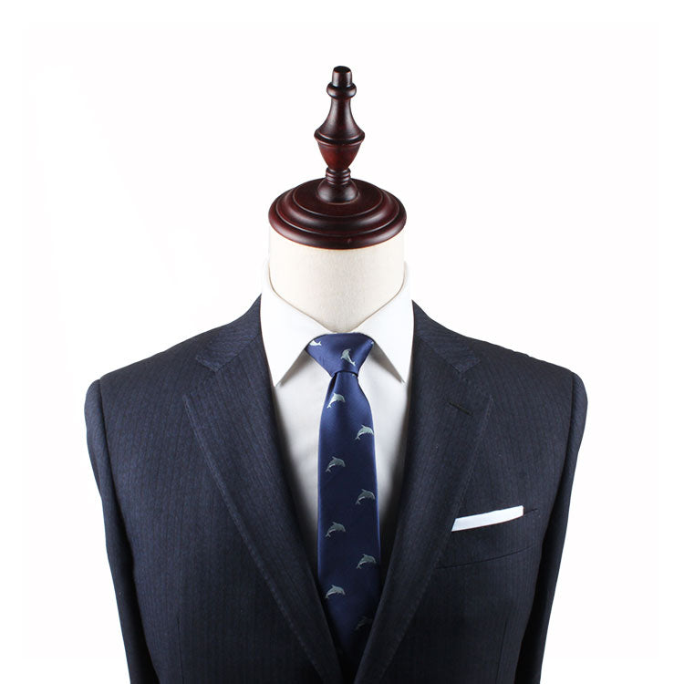 A mannequin displays a dark suit with a white dress shirt, a Dolphin Slim Tie, and a white pocket square, perfect for ocean enthusiasts.