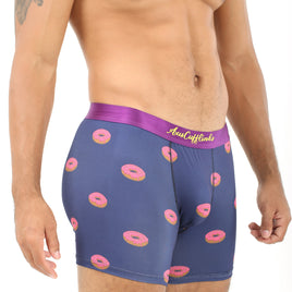 A man wears the Donuts Underwear, featuring navy boxer briefs with a fun pink donut pattern and a purple waistband, offering both comfort and a sweet touch.