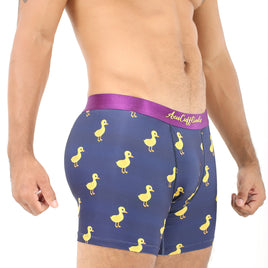 A man wearing Duck Underwear—navy blue boxer briefs adorned with a cheerful yellow duck pattern and featuring a vibrant pink waistband—stands against a white background, exuding plush comfort.