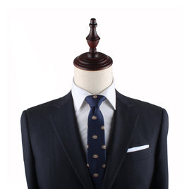 A headless mannequin dressed in a dark suit with a white shirt and a Dumplings Slim Tie, exuding timeless elegance.