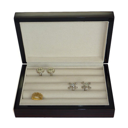 The Ebony Wood Cufflink Box elegantly displays a gold ring and two pairs of silver cufflinks on a cream-colored interior, offering a stylish and organized storage solution.