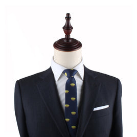 A mannequin dressed in a dark suit, white shirt, and the Egg Tart Slim Tie with yellow patterns stands as a delightful testament to sophisticated fashion.