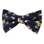 Introducing the Floral Navy Yellow Self Bow Tie, featuring a pattern of small yellow and white flowers and green leaves — a piece that exudes unique elegance.