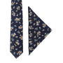 The Floral Navy Yellow Skinny Cotton Tie and Pocket Square set showcases golden blossoms intertwined with a floral pattern on a pristine white background.