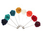 Eight fabric flower lapel pins, including the maroon pin, are arranged semi-circularly with metal pins extending outward. These colorful accessories add a stylish flair to any outfit.
