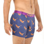 A person wearing the Flying Eagle Underwear —navy blue boxer briefs with an eagle print and a purple waistband— stands against a white background, evoking the freedom to soar through open skies.