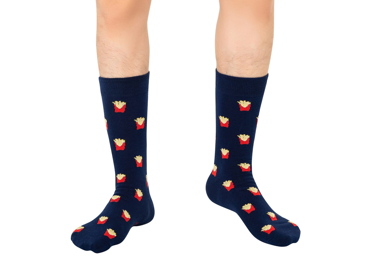 A person wears Fries Socks—navy blue socks featuring red French fry containers—while standing on a white background.