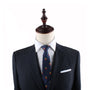 A mannequin dressed in a dark suit with a white dress shirt, the Fries Slim Tie featuring red and yellow accents, and a white pocket square exudes modern sophistication.