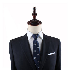 A dark grey suit with a white dress shirt and a Game Controller Slim Tie is displayed on a mannequin with a wooden finial, perfectly capturing the style sought by trendsetters.