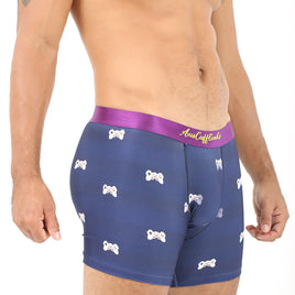 A man wearing the Game Controller Underwear, designed with navy blue fabric featuring bone patterns and a purple waistband, stands against a white background. His torso and upper thighs are visible, highlighting comfort that elevates your daily style.