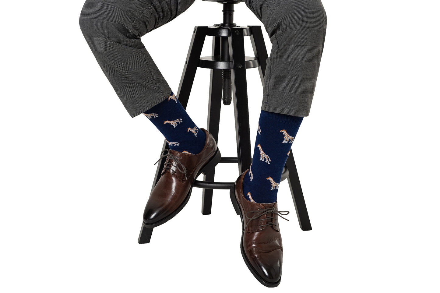A man sitting on a stool wearing Giraffe Socks.