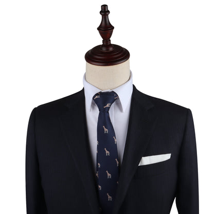 A suit on a mannequin stands tall, featuring a dark jacket, white dress shirt, and the Giraffe Print Tie with a subtle small animal print. Sophistication is elevated with the addition of a crisp white pocket square tucked into the breast pocket.