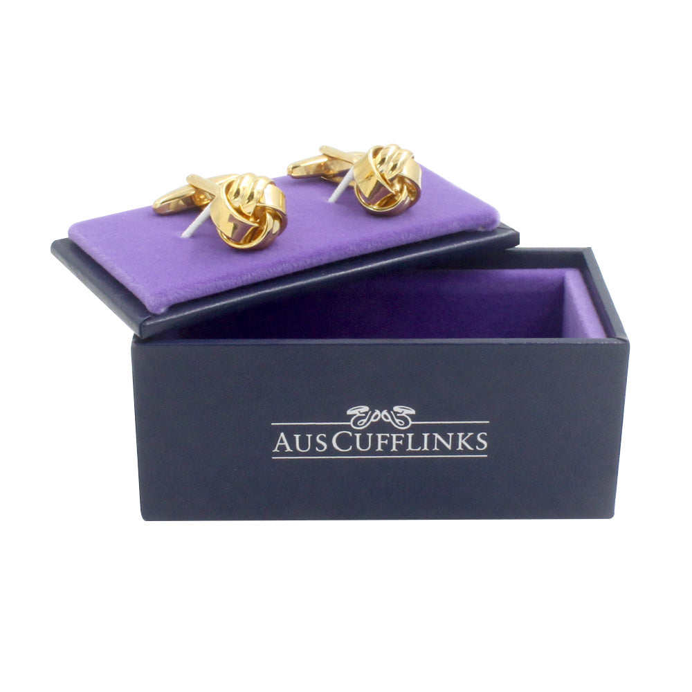 A pair of Gold Knot Cufflinks sits on a purple velvet insert inside a black box labeled "AUSCufflinks," radiating an air of wedding elegance.