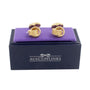 The Golden Link Cufflinks, exuding opulence, are elegantly displayed on a purple cushion atop a black box labeled "AusCufflinks," perfectly connecting style with sophistication.