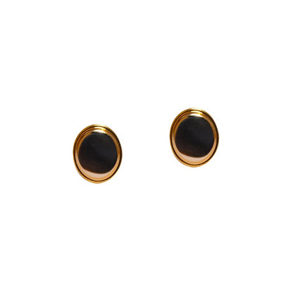 The round black stud earrings with gold trim, set on a white background, exude sophistication similar to the Golden Silver Cufflinks' elegance.