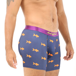 A person in Goldfish Underwear, featuring a vibrant purple design with orange fish patterns, stands sideways, showcasing a tattooed arm and part of the torso, ready to swim in ultimate comfort.