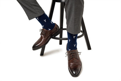 A man wearing a pair of Golf Swing Socks is sitting on a stool.
