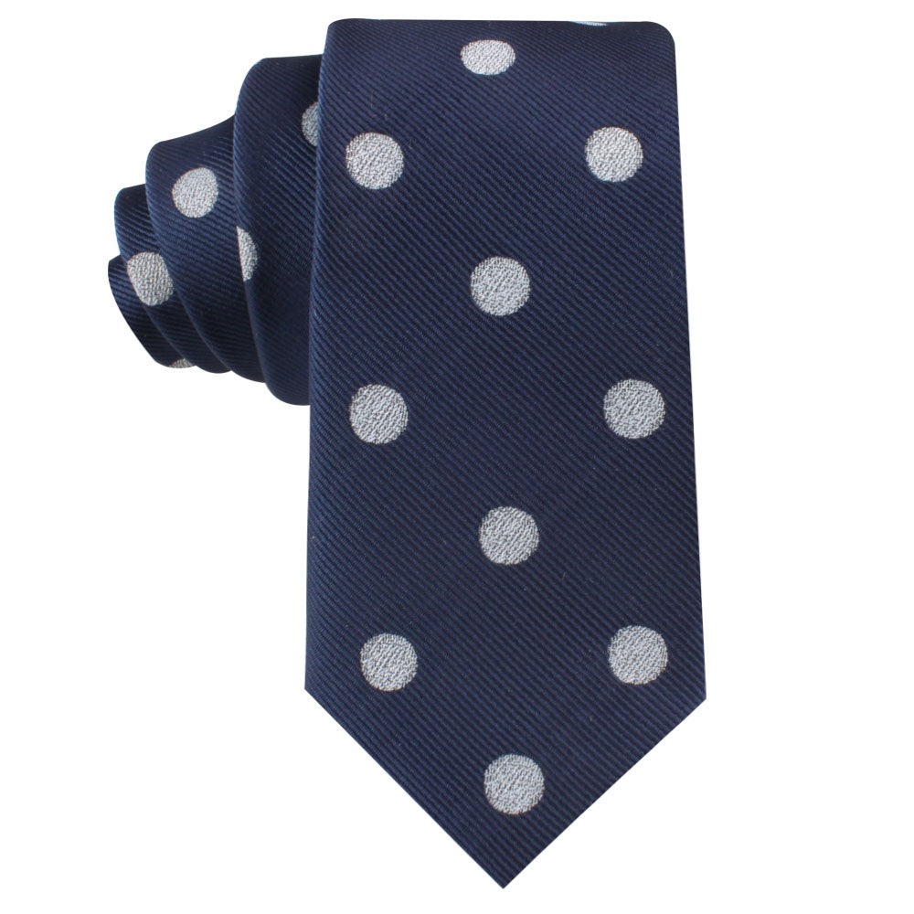 The Golf Ball Thin Tie, featuring large white polka dots on a dark blue background and neatly rolled, is perfect for enthusiasts looking to add a playful flair to their attire.