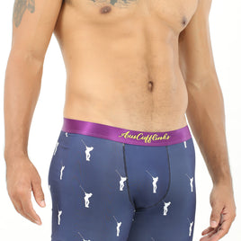 A man with tattooed arms models the Golf Swing Underwear, featuring dark blue boxer briefs with a purple waistband and white golfer prints, perfectly showcasing the ultimate drive for comfort.