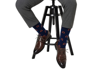 A man sitting on a stool wearing Headphones Socks.