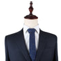 Mannequin dressed in a dark pinstriped suit jacket, white dress shirt, and an elegant Horse Print Tie featuring small patterns, set against a plain white background.