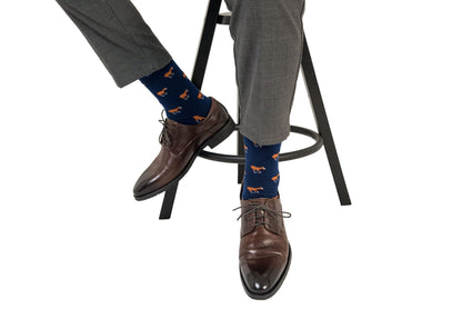A man sitting on a stool wearing Horse Socks.