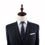 A headless mannequin exudes charisma, dressed in a dark suit with a white shirt, complemented by the Hotdog Slim Tie featuring small motifs and a crisp white pocket square.