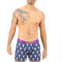 A man with a tattoo is standing in a pair of Jesus Boxer, featuring blue boxer briefs with white patterns, exuding a heavenly feel against the white background.