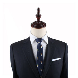 A mannequin dressed in a dark suit, white dress shirt, and the Kebab Slim Tie savor the essence of timeless elegance.