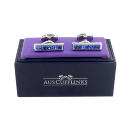 Blue Ice Cufflinks – Cool & Sleek Style: rectangular silver cufflinks with blue stones, shown on a purple cushion above a black AUS CUFFLINKS box.