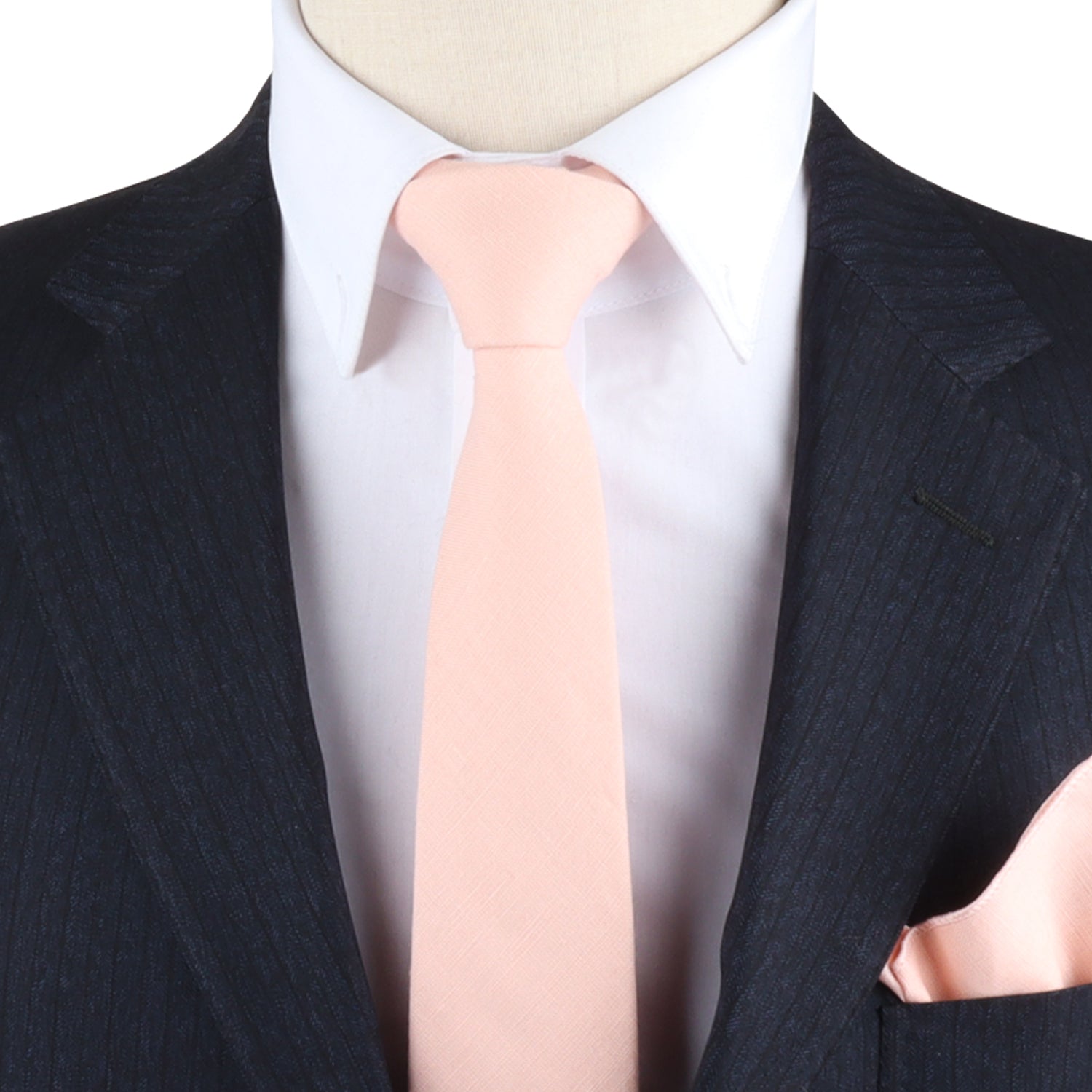 Close-up of a person wearing a suit with a white shirt, Baby Pink Skinny Tie, and matching pink pocket square woven with pastel threads, exuding charm.