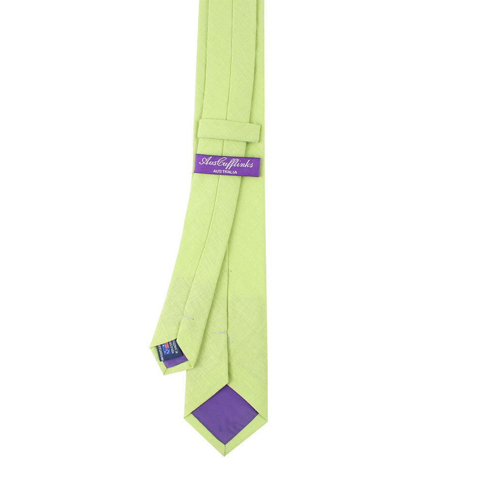 The Lime Green Cotton Skinny Tie, adorned with a playful purple label and inner lining, captures the essence of spring with its vibrant style.