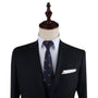 A mannequin dressed in a dark suit jacket, white dress shirt, and Lion Print Tie with a small pattern, exuding an air of authority as the leader in style. It has a white pocket square in the breast pocket.