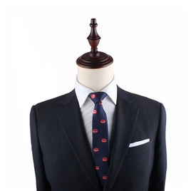 A headless mannequin is dressed in a dark suit, white shirt, Macaron Skinny Tie with red patterns, and a white pocket square.