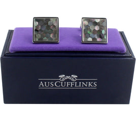 A pair of Signature Malachite Cufflinks with a stellar mosaic design, presented on a purple cushion inside an "auscufflinks" branded box.
