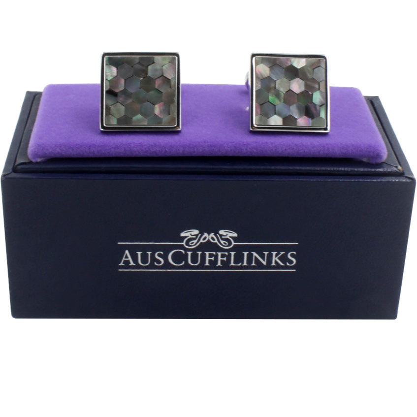 A pair of Signature Malachite Cufflinks with a stellar mosaic design, presented on a purple cushion inside an "auscufflinks" branded box.