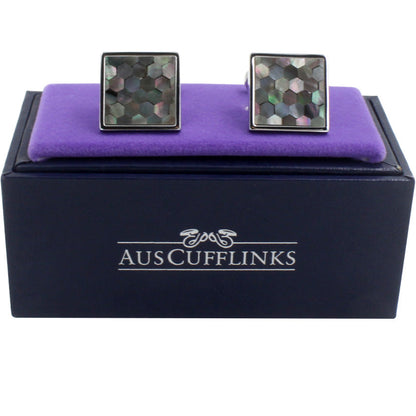 A pair of Signature Malachite Cufflinks with a stellar mosaic design, presented on a purple cushion inside an "auscufflinks" branded box.