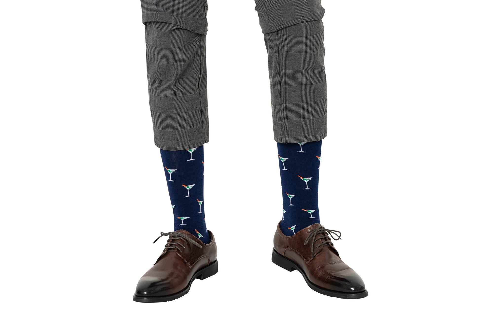 A person showcasing a strong sock game with Martini Margarita Socks, featuring a cocktail glass pattern, perfectly paired with gray pants and brown dress shoes.