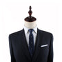A mannequin dressed in a classic dark suit, white dress shirt, and the Martini Slim Tie in navy blue with a white pattern.