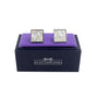 The Light Ocean Mosaic Cufflinks featuring a hexagonal pattern are elegantly placed on a purple cushion in a black "AUSCUFFLINKS" box. Ideal for the modern gentleman, these luxury cufflinks bring sophistication to any ensemble.