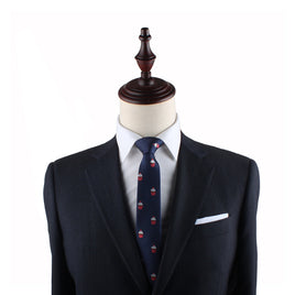 A mannequin dressed in a dark suit makes a delectable style statement with its crisp white shirt and the Muffin Slim Tie against a white background.