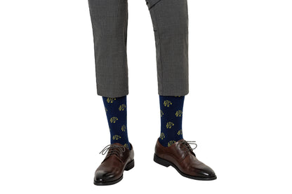 A pair of brown dress shoes and grey trousers with Musical Note Socks featuring turtle patterns harmonize on the feet.