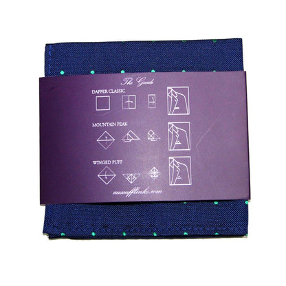 The Navy Green Polka Dot Business Tie & Pocket Square Set is designed for the modern gentleman, featuring a navy blue pocket square with green dots. It is elegantly wrapped with a purple band and illustrated instructions for three folding styles, perfectly complementing the tie.