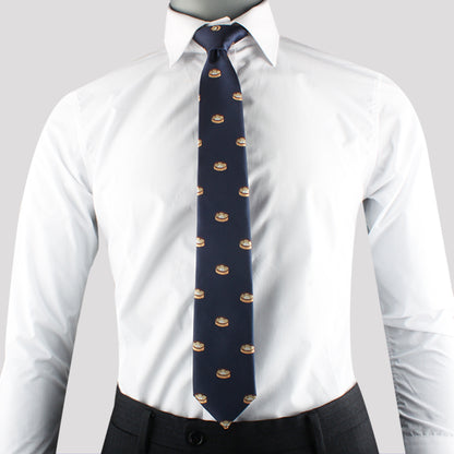A person is wearing a white dress shirt with a Dumplings Skinny Tie, exuding timeless elegance. The outfit is paired with dark pants.