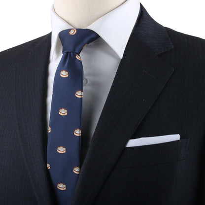 A person in a dark suit with a white dress shirt and a Dumplings Skinny Tie featuring a circular pattern exudes timeless elegance.