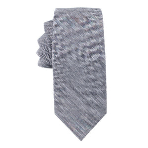 A neatly folded, Navy Blue Herringbone Skinny Cotton Tie Tie exudes sophistication.