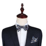The mannequin wears a dark suit paired with a Navy Multi Floral Self Tie Bow Tie and matching pocket square, perfect for weddings, against a plain backdrop.